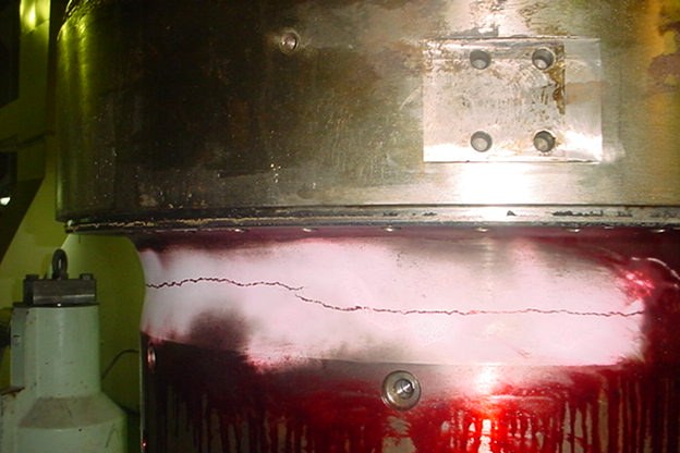 Cylinder liner with a horizontal crack shown by red dye penetrant on white developer
