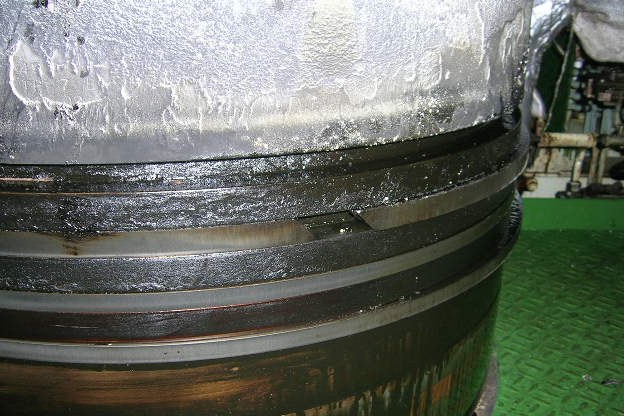 Ring pack of a piston removed from the engine, with oil and deposits around the rings