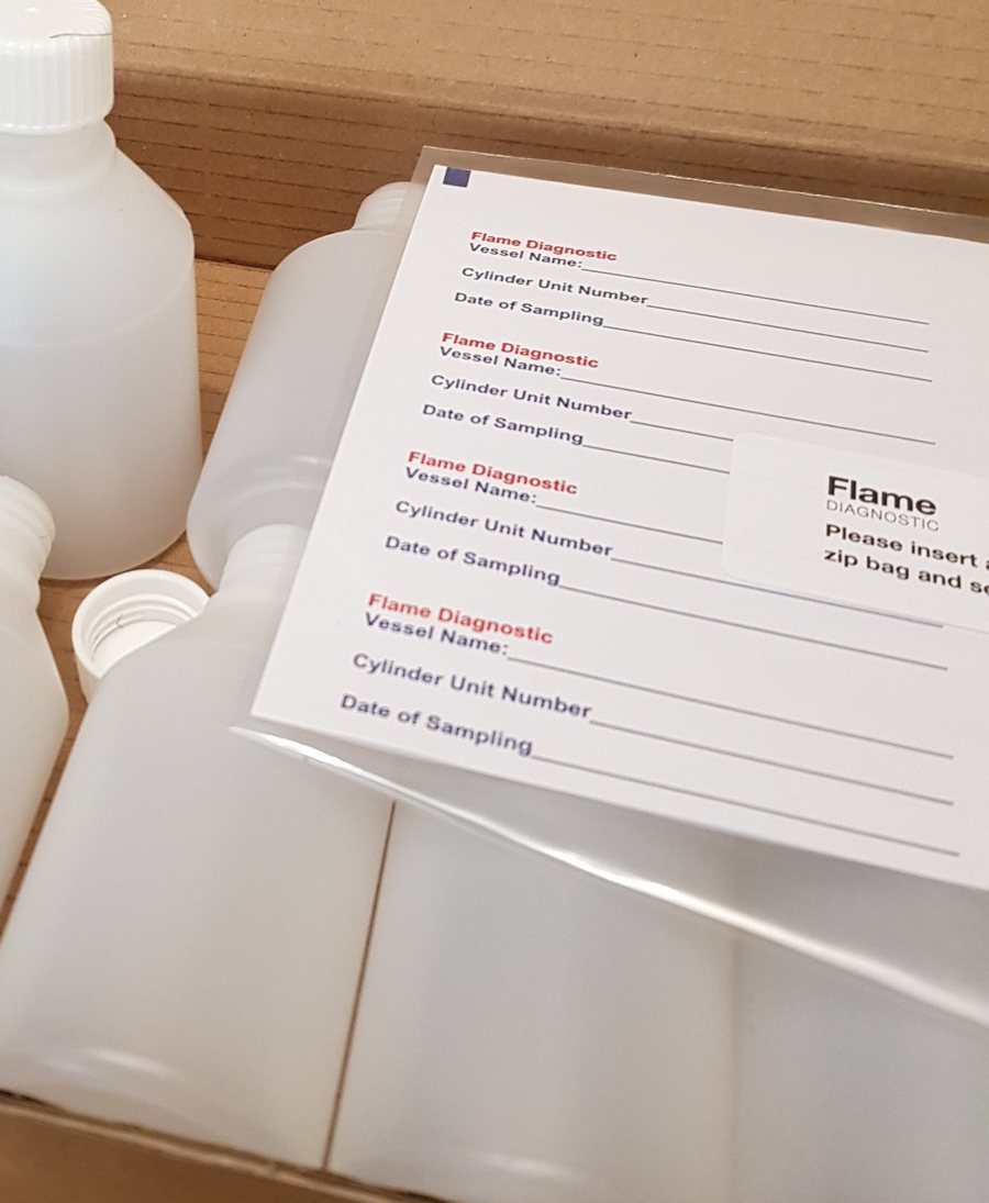 Open sampling kit: a box of sample bottles with zip bags and a sheet of labels, each marked Flame Diagnostic with spaces for vessel name, cylinder unit number and date of sampling