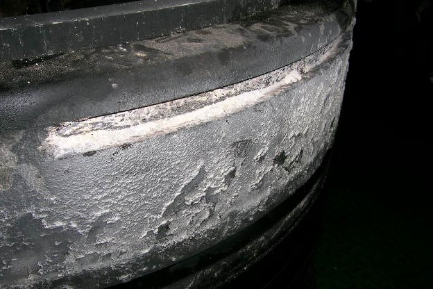 Hard pale deposit band on the top land of a piston above the ring pack